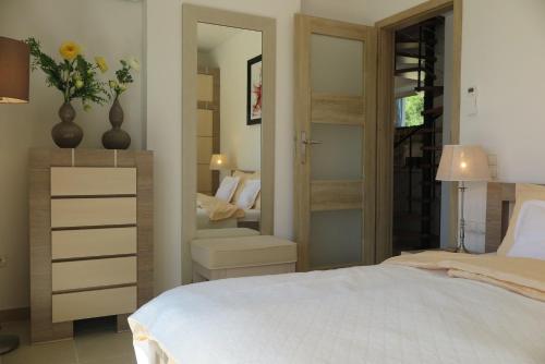- une chambre avec un lit blanc et un miroir dans l'établissement ARILLAS HILLSIDE VILLA 3 - Provence, à Arillas