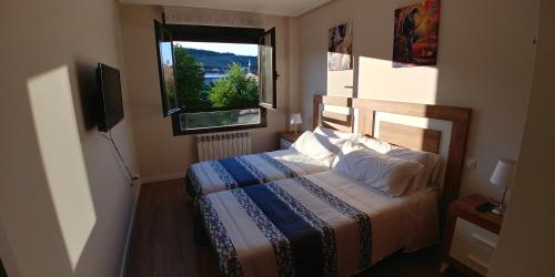 FuenmayorにあるApartamento ENTREVIÑAS en el corazón de La Riojaのベッドルーム(ベッド1台、窓付)