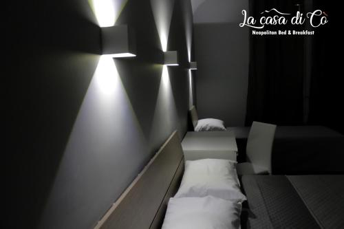 a room with two beds and lights on the wall at B&B La casa di Cò in Naples