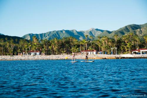 two people are on a paddle board in the water at Rancho Las Cruces in Las Cruces
