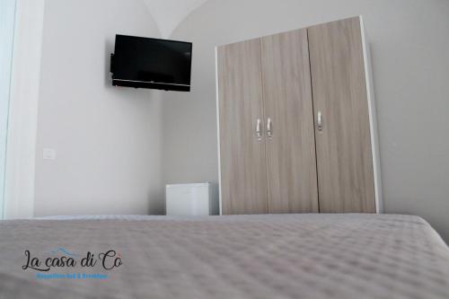 a bedroom with a bed and a cabinet with a television at B&B La casa di Cò in Naples