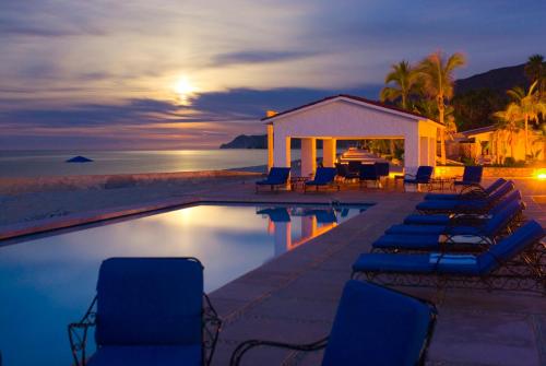 a resort pool with chairs and a gazebo at Rancho Las Cruces in Las Cruces