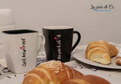 a table with two plates of pastries and a coffee mug at B&B La casa di Cò in Naples