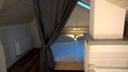 a bedroom with a blue bed with a window at Atelier im Huus Hillig-Geist in Flensburg