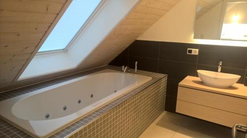 a bathroom with a tub and a sink and a window at Atelier im Huus Hillig-Geist in Flensburg