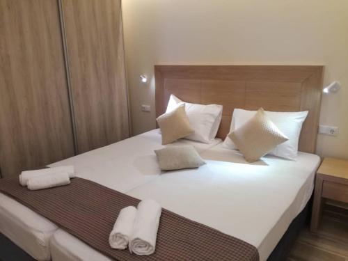 a bedroom with a large white bed with towels on it at Stami's Seaside Apartment in Pyrgi