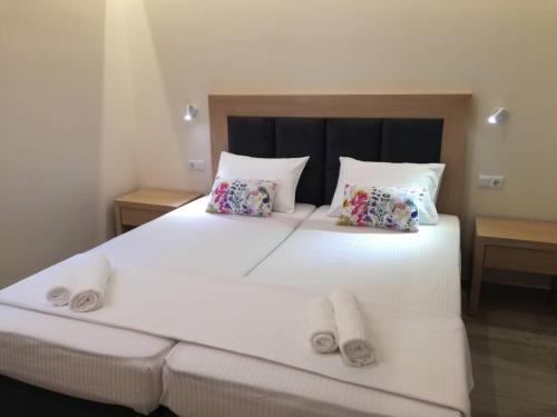a bedroom with a large white bed with two pillows at Stami's Seaside Apartment in Pyrgi