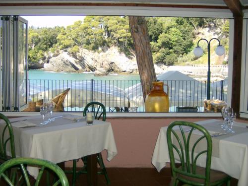 a restaurant with two tables and a view of the water at Hotel Fiascherino in Lerici