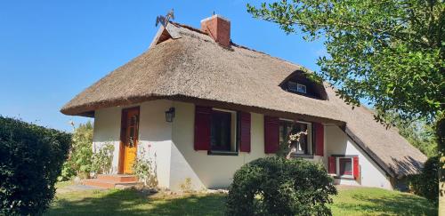a thatch roofed house with a thatched roof at Ferienhaus Annelore in Middelhagen