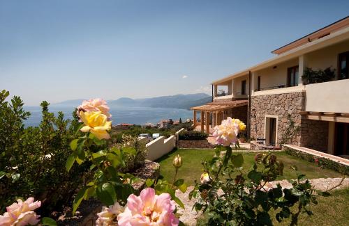 a house with a view of a yard with flowers at Hotel Villa Gustui Maris in Cala Gonone