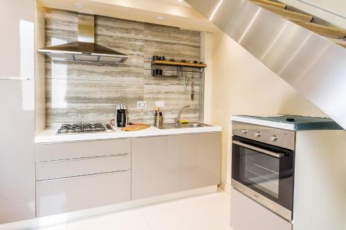 a kitchen with white cabinets and a stove at Sanremo Home Loft in Sanremo