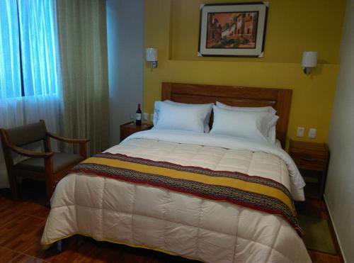 a bedroom with a large bed with a yellow wall at Picos House MachuPicchu in Machu Picchu