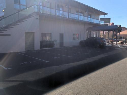 a car parked in a parking lot next to a building at New England Motor Inn in Armidale