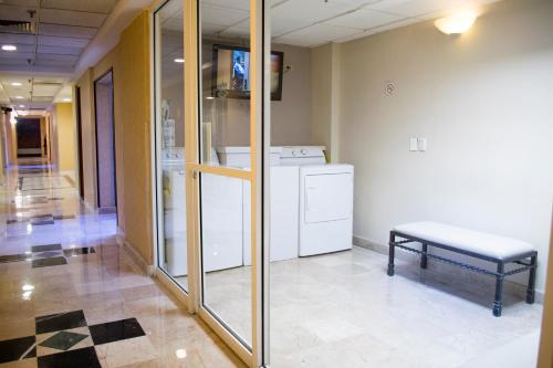 a hospital hallway with a washer and dryer and a bench at iStay Hotel Ciudad Juarez in Ciudad Juárez