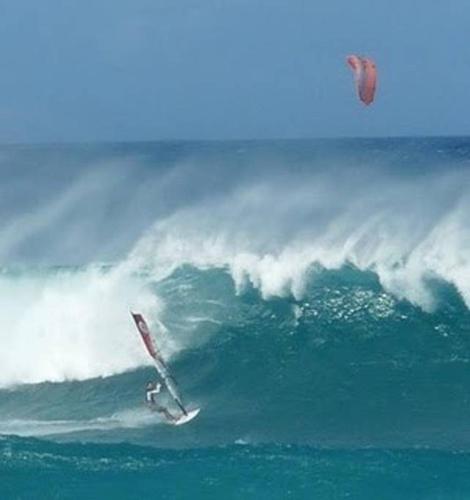 a person riding a wave on a surfboard in the ocean at Bamboo Valley Inn in Haiku