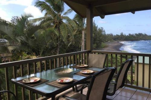 Una mesa en un balcón con vista al mar. en Kailani Suite at hana Kai Resort, en Hana