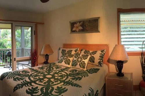 a bedroom with a bed and two lamps and a window at Kailani Suite at hana Kai Resort in Hana