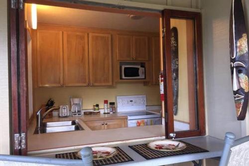 a small kitchen with a sink and a microwave at Kailani Suite at hana Kai Resort in Hana