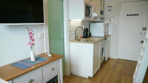 a small kitchen with white cabinets and a sink at Boulevard de la Mer 33 Apartam 11 in Hendaye