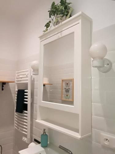 La salle de bains est pourvue d'un miroir blanc et d'un lavabo. dans l'établissement Boulevard de la Mer 33 Apartam 11, à Hendaye