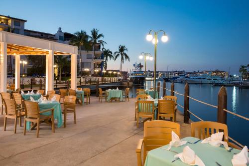 a restaurant with tables and chairs next to the water at Vamar Vallarta All Inclusive Marina & Beach Resort in Puerto Vallarta