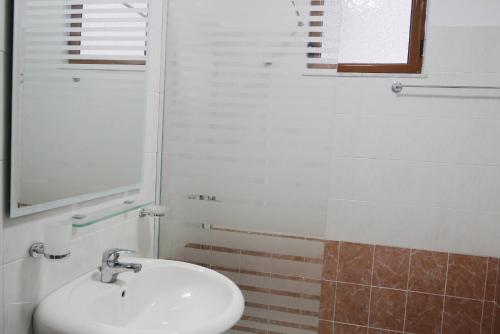 uma casa de banho com um lavatório e um espelho em Victoria's Sea-Cret em Saranda
