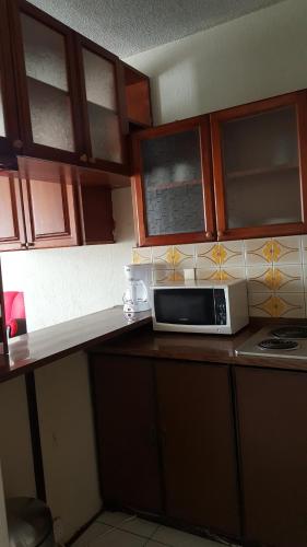 a microwave sitting on a counter in a kitchen at Apartment business/airport area Guatemala City in Guatemala