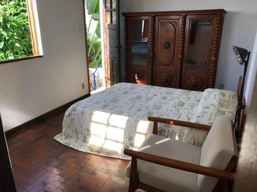 1 dormitorio con 1 cama, 1 silla y 1 ventana en Guest house with stunning view, en Río de Janeiro