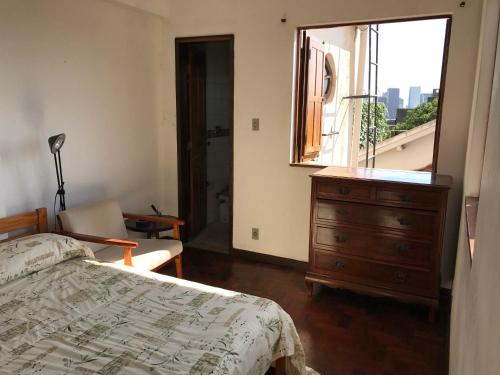 1 dormitorio con 1 cama, vestidor y ventana en Guest house with stunning view, en Río de Janeiro