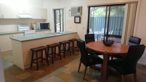 cocina y comedor con mesa y sillas en Shepparton Golf Motel, en Shepparton