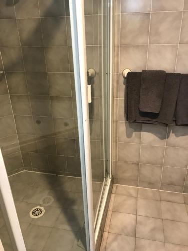 een badkamer met een douche en zwarte handdoeken bij Tea Gardens Motel in Tea Gardens