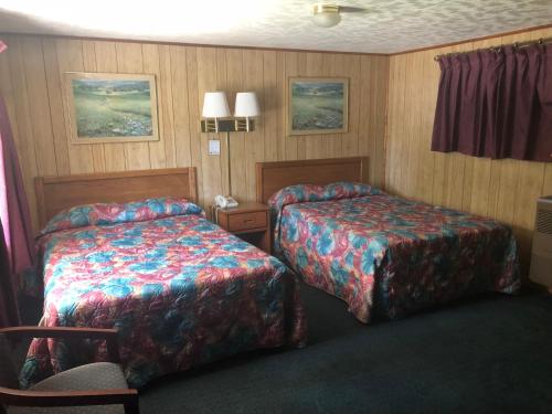 a hotel room with two beds and a chair at Elmwood Motor Lodge in Boscawen