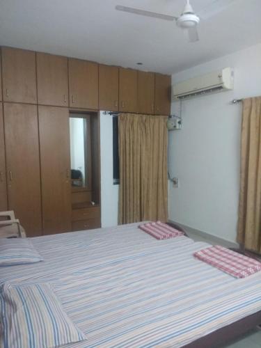 a bedroom with a large bed and wooden cabinets at Gerones Residency Serviced Apartments & Home Stays in Coimbatore