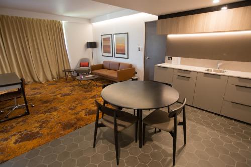 a room with a kitchen and a table and chairs at Crowne Plaza Alice Springs Lasseters, an IHG Hotel in Alice Springs