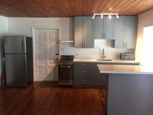 a kitchen with a stainless steel refrigerator and wooden floors at Bimini Seaside Villas - Pink Cottage with Beach View in Alice Town