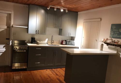 a kitchen with gray cabinets and a white counter top at Bimini Seaside Villas - Pink Cottage with Beach View in Alice Town