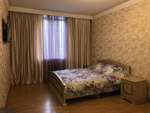 ウラジカフカスにあるTwo-Bedroom Apartment on Vatutinaのベッドルーム1室(窓の前にベッド1台付)