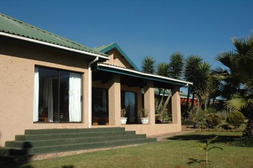 a house with stairs leading up to a window at Elephant's Nest in Graskop