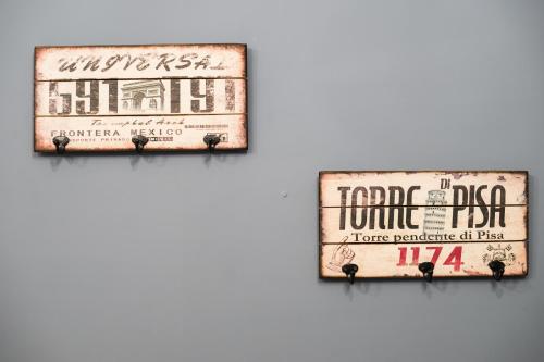 two signs hanging on a wall at Tainan Little Day in Tainan