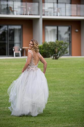 a woman in a wedding dress standing in the grass at Macquarie 4 Star in Warners Bay