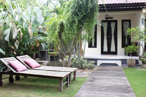 a patio with a bench in front of a house at Giri Sari Guest House Pemuteran Bali in Pemuteran