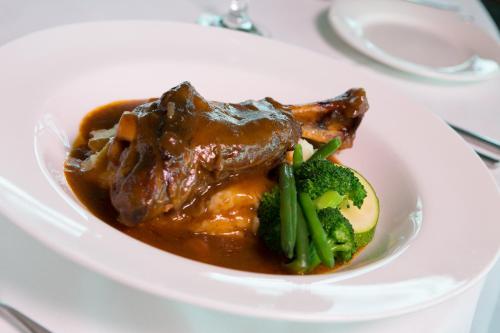 a plate of food with meat and broccoli on a table at Macquarie 4 Star in Warners Bay