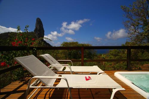 a couple of chairs sitting on a deck next to a pool at Pousada Zé Maria in Fernando de Noronha