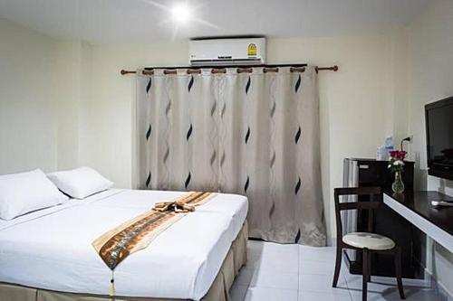 a bedroom with a bed and a laptop on top of it at Star 3 Hotel and Residence in Rayong
