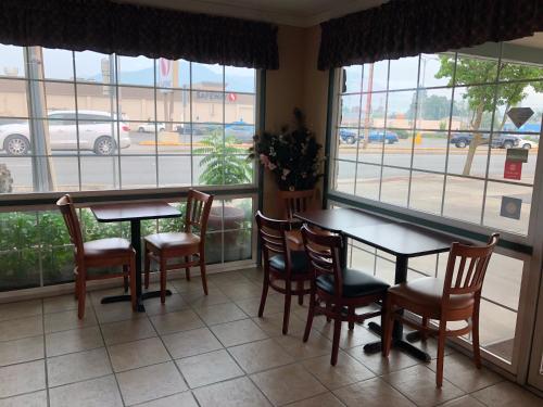 a dining room with tables and chairs and windows at Knights Inn Motel in Grants Pass
