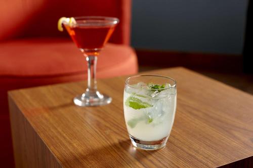 a drink and a wine glass on a wooden table at Hyatt Place-Dallas/Arlington in Arlington