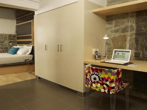 a kitchen with a refrigerator and a table at Hotel le Priori in Quebec City