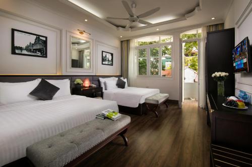 a bedroom with two beds and a television in it at Golden Rooster Hotel in Hanoi