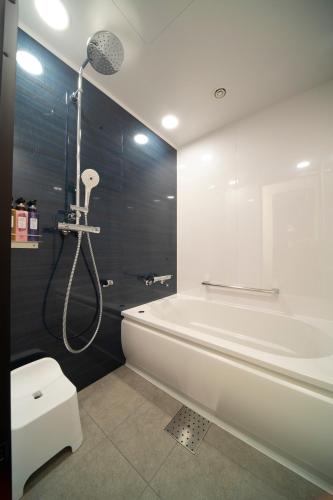 a bathroom with a shower and a tub and a toilet at Hotel Vischio Osaka-JR Hotel Group in Osaka