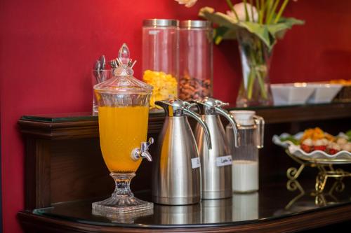 a glass cup of orange juice sitting on a table at Golden Rooster Hotel in Hanoi